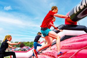people running up inflatable obstacle course