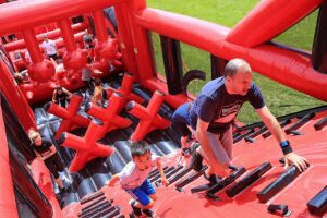 people climbing up inflatable obstacle course