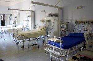 An image of a hospital ward with multiple hospital beds.