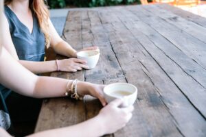 Women talking over coffee. Women’s Mental Health & Wellbeing.